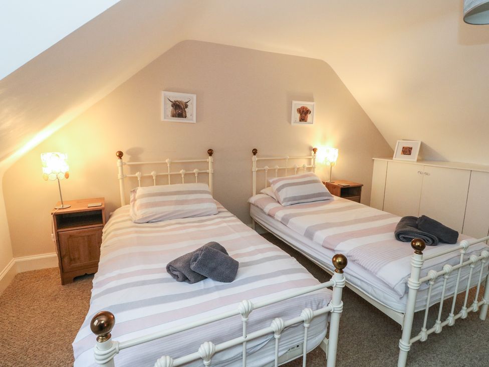 A bedroom with two beds and nightstands at The Cottage in Perth