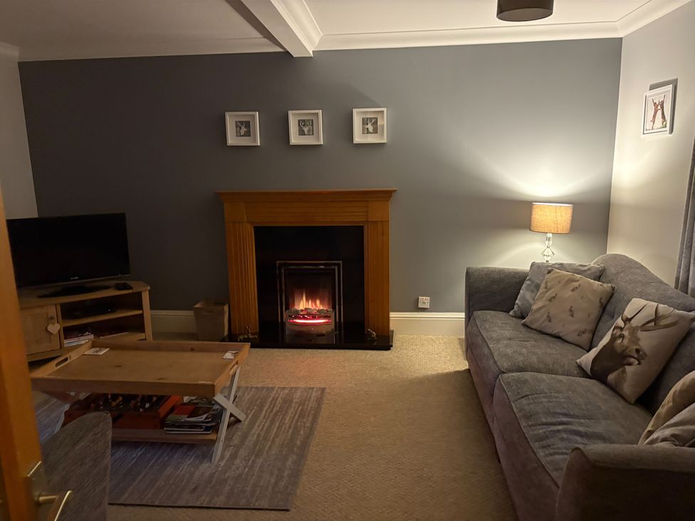 A living room with a fireplace and sofa at The Cottage in Methven