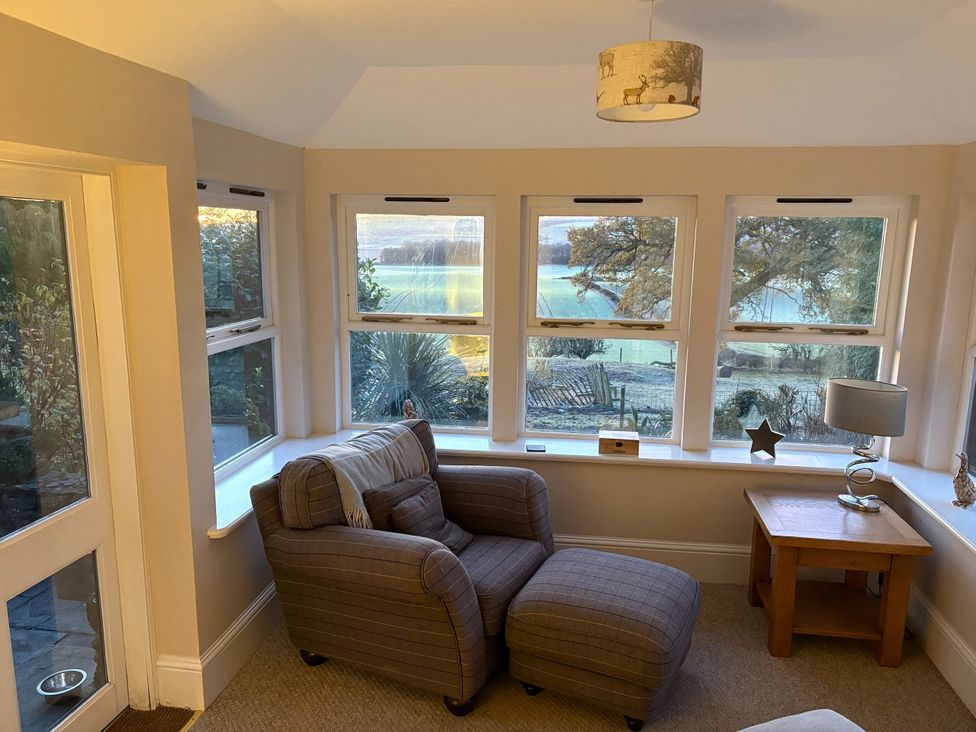 A snug with an armchair and side table at The Cottage in Methven