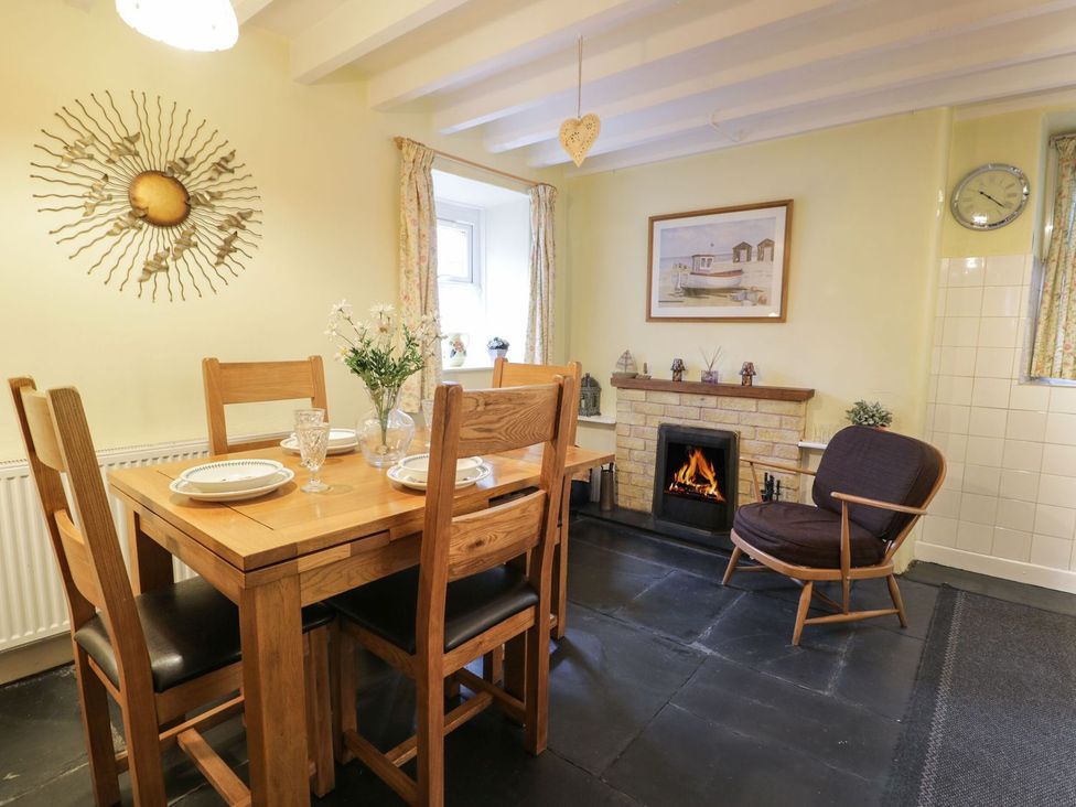 A dining room with a table and chairs at Noddfa in Penmachno
