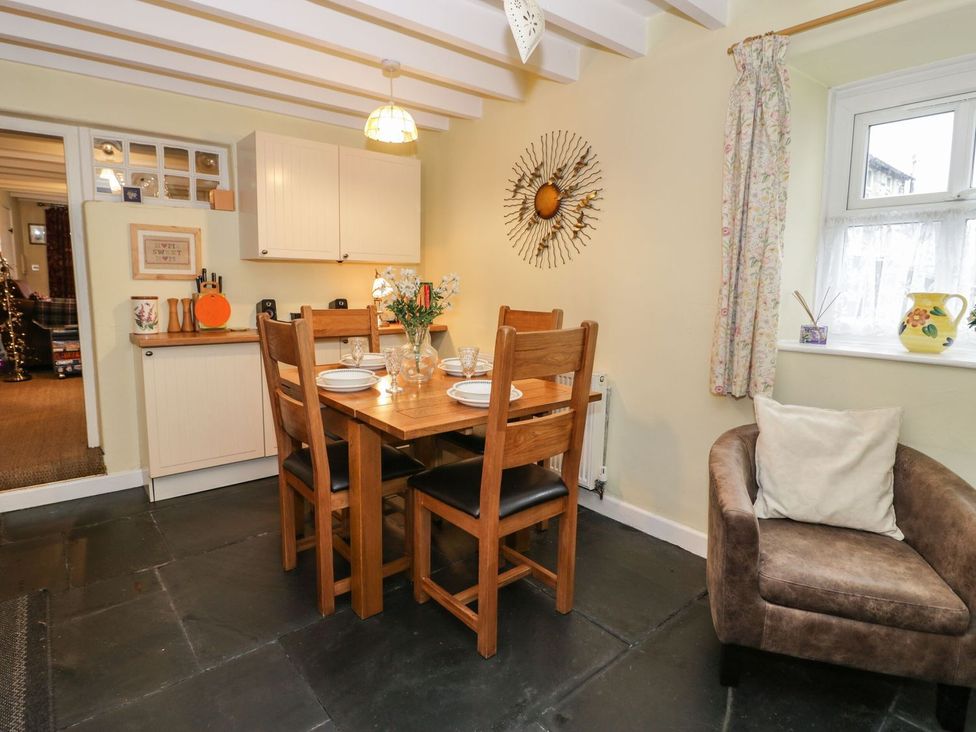 A dining room with a table and chairs at Noddfa in Penmachno