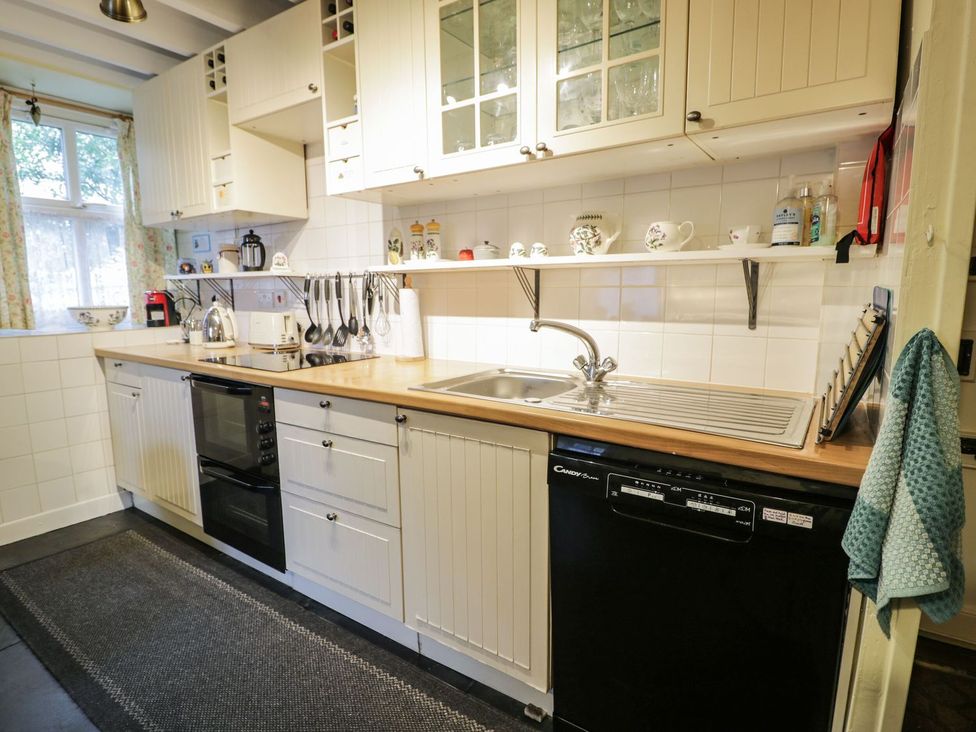 A kitchen with cabinets and appliances at Noddfa Penmachno
