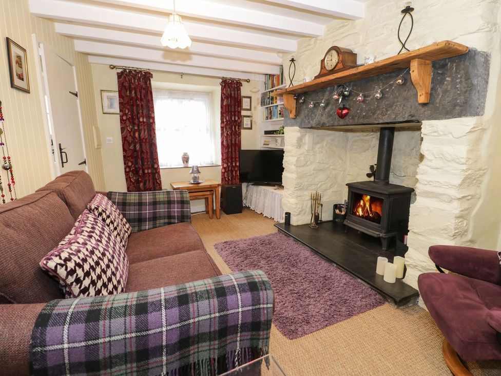 A living room with a fireplace and sofa at Noddfa in Penmachno