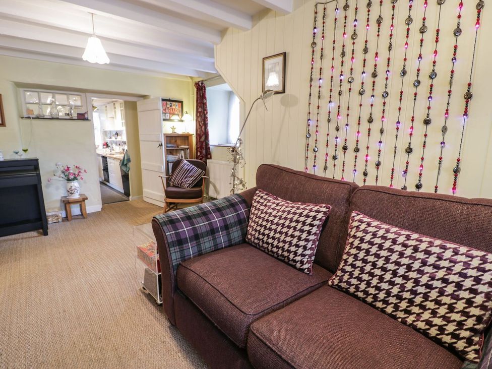 A living room with a sofa and table at Noddfa in Penmachno