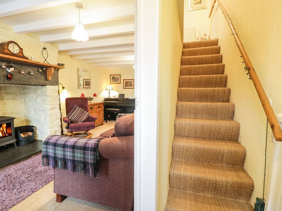 A living room with a sofa and fireplace at Noddfa Penmachno