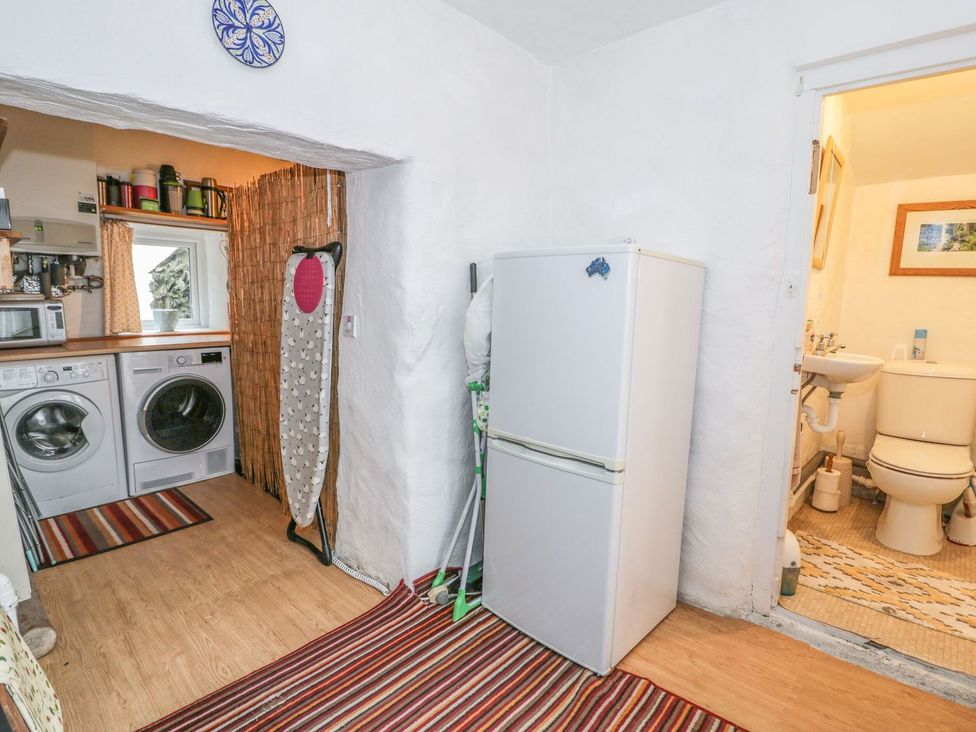 A laundry room with washing machines and a refrigerator at Noddfa in Penmachno