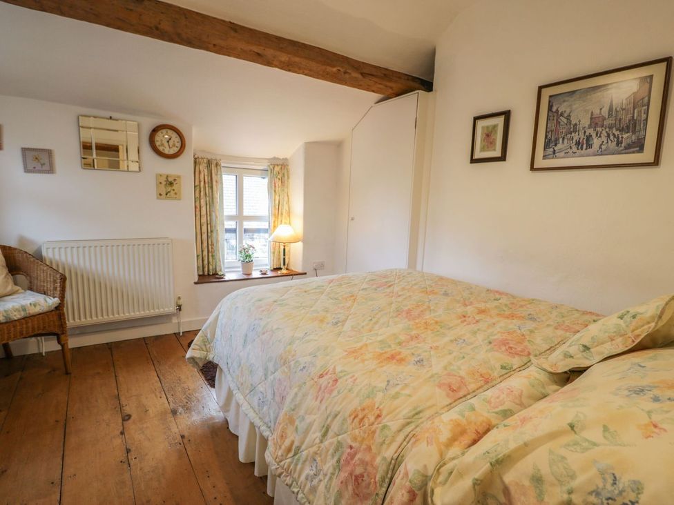 A bedroom with a bed and chair at Noddfa in Penmachno