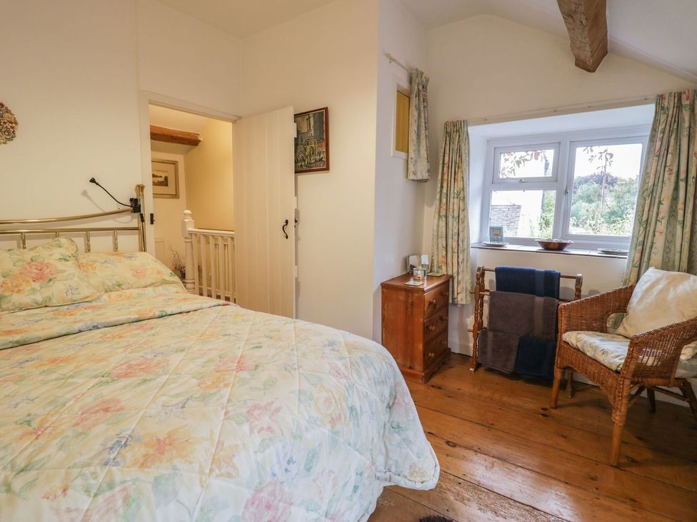 A bedroom with a bed and nightstand at Noddfa in Penmachno