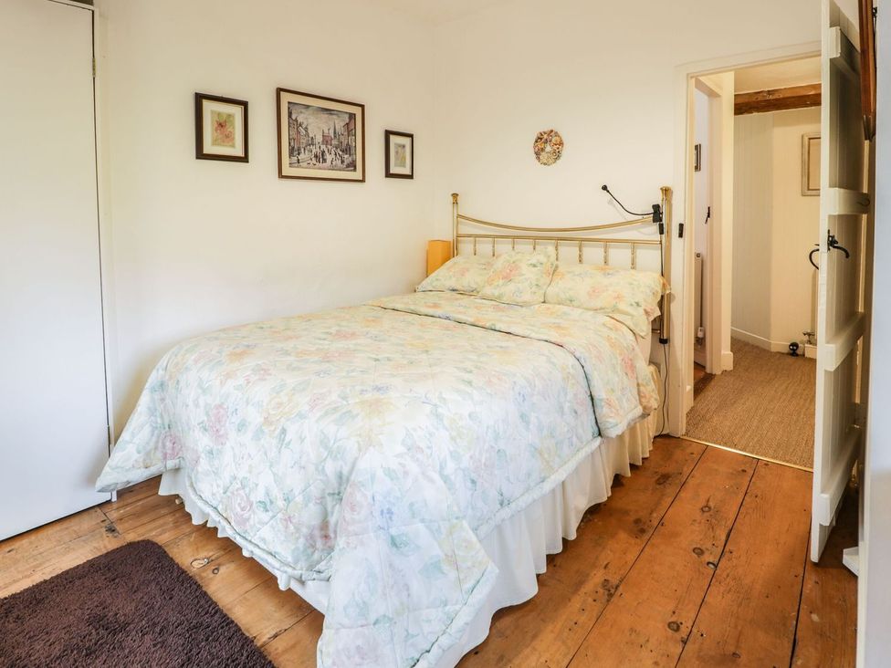 A bedroom with a bed and wall art at Noddfa in Penmachno