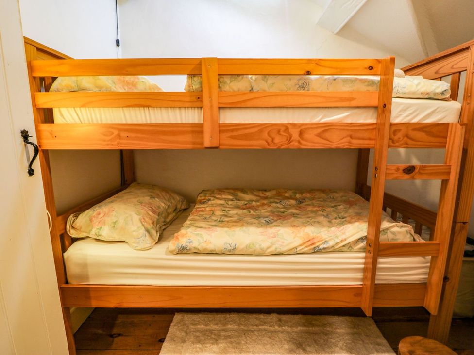 A bunk bed with mattresses and pillows at Noddfa Penmachno
