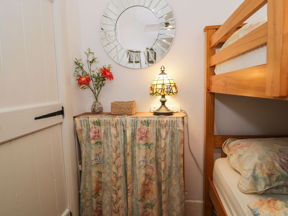 A bedroom with a bunk bed and decorative items at Noddfa in Penmachno