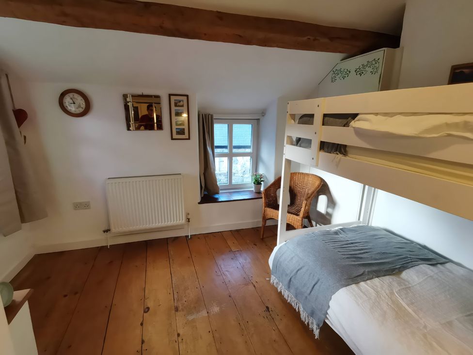 A bedroom with a bunk bed and a single bed at Noddfa in Penmachno