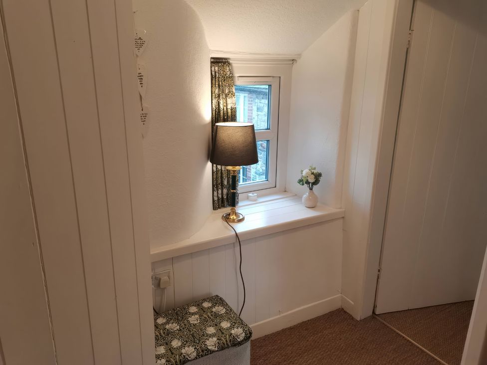 A hallway with a lamp and window at Noddfa Penmachno