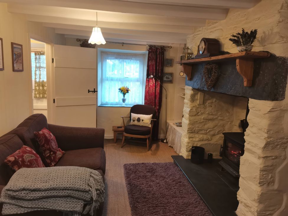 A living room with a sofa and fireplace at Noddfa in Penmachno