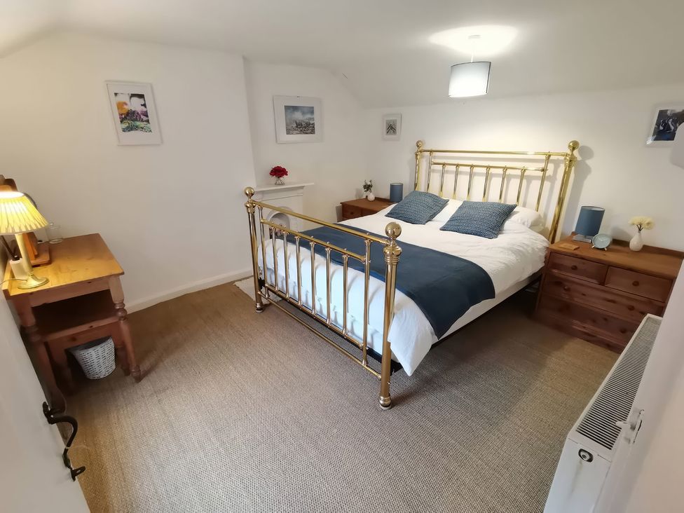 A bedroom with a bed and nightstands at Noddfa in Penmachno