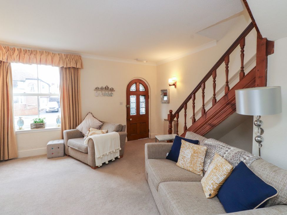 A living room with a sofa and armchair at The Hideaway in Penrhyn Bay