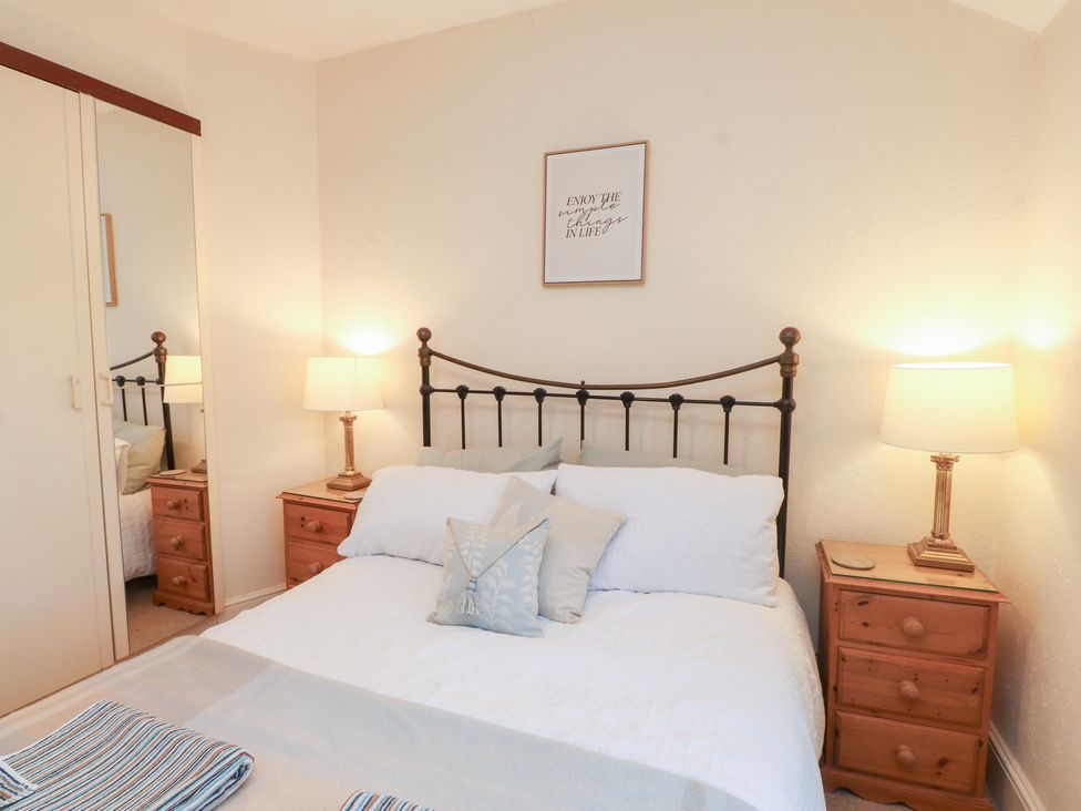 A bedroom with a bed and bedside tables at The Hideaway Penrhyn Bay
