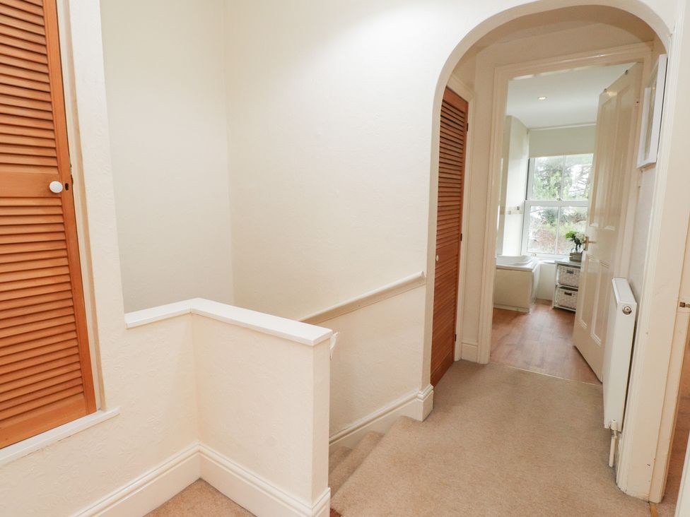 A hallway with a staircase and door leading to a room at The Hideaway in Penrhyn Bay