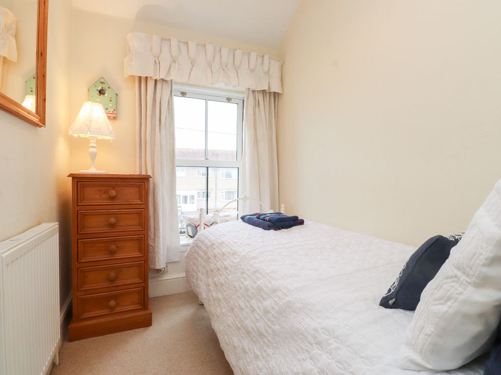 A bedroom with a bed and a dresser at The Hideaway in Penrhyn Bay