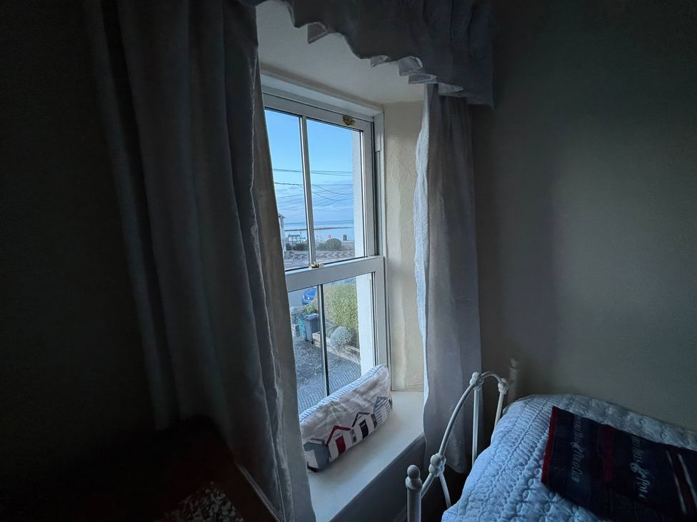 A window with curtains in a bedroom at The Hideaway Penrhyn Bay
