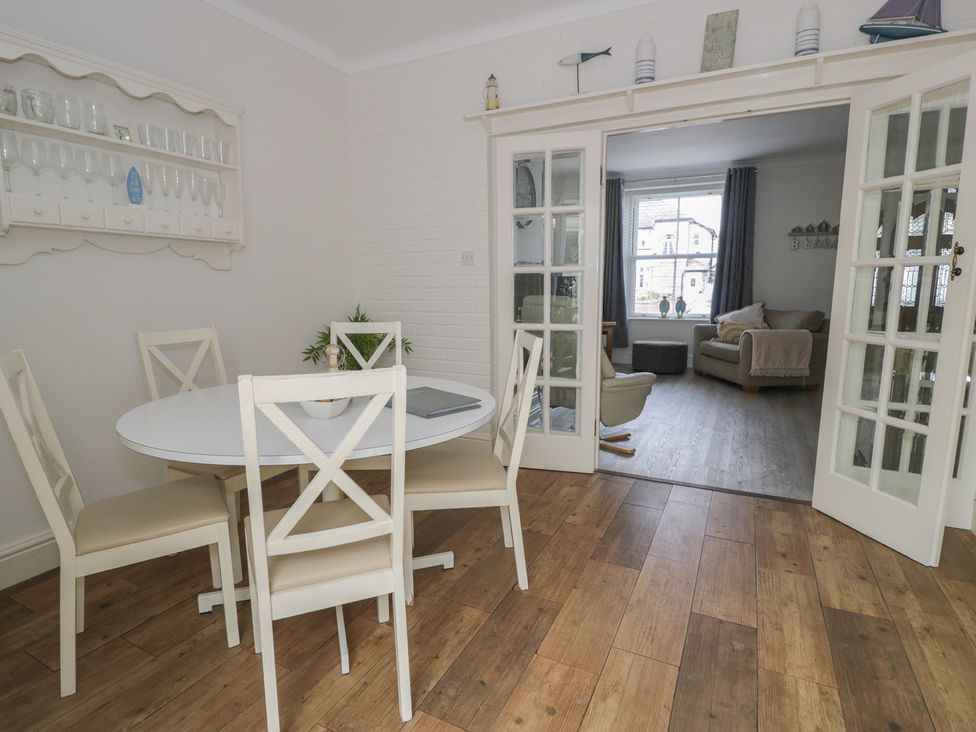 A dining room with a round table and chairs at The Hideaway in Penrhyn Bay