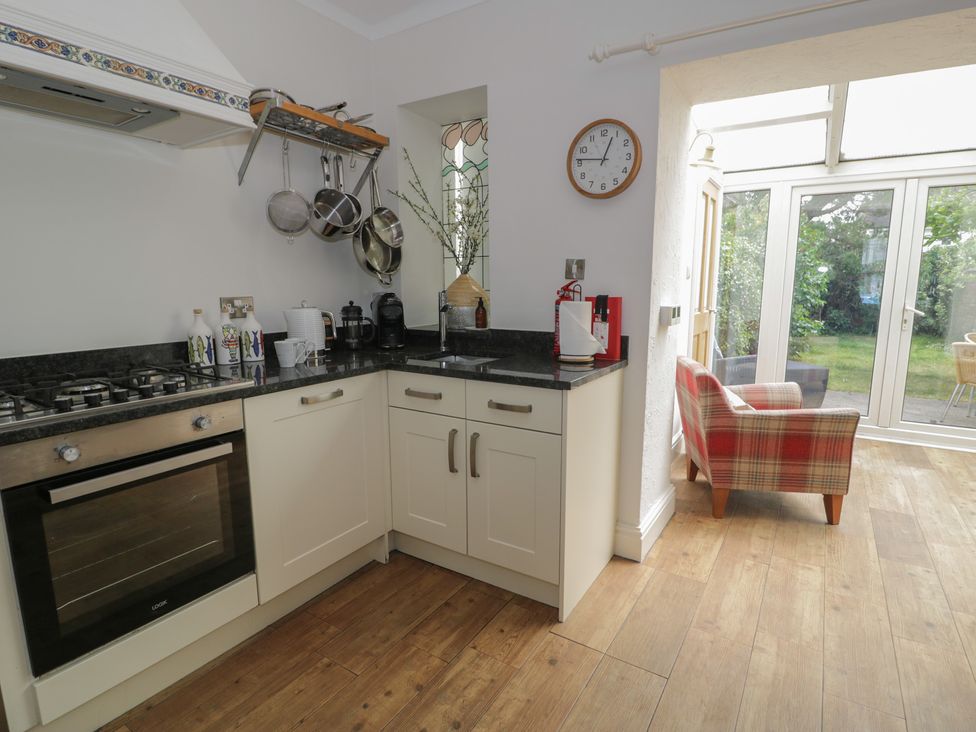 A kitchen with a stove and sink at The Hideaway in Penrhyn Bay