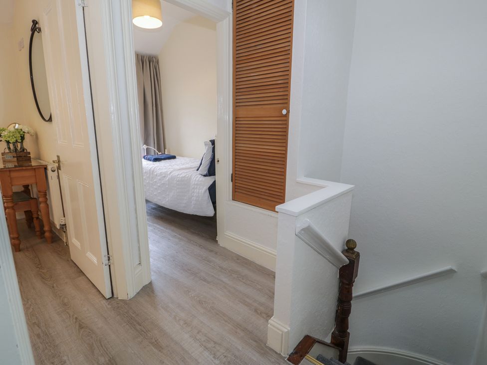 A hallway with a mirror and table at The Hideaway in Penrhyn Bay