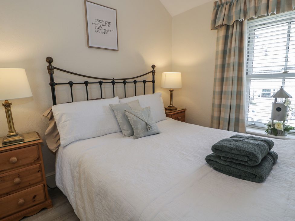 A bedroom with a bed and bedside tables at The Hideaway in Penrhyn Bay