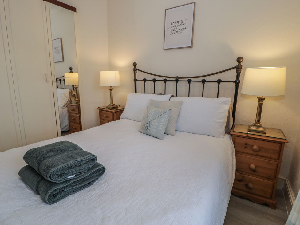 A bedroom with a bed and bedside tables at The Hideaway in Penrhyn Bay