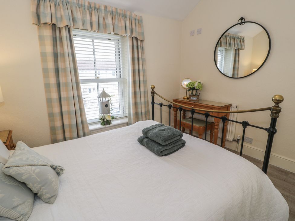 A bedroom with a bed and bedside table at The Hideaway in Penrhyn Bay