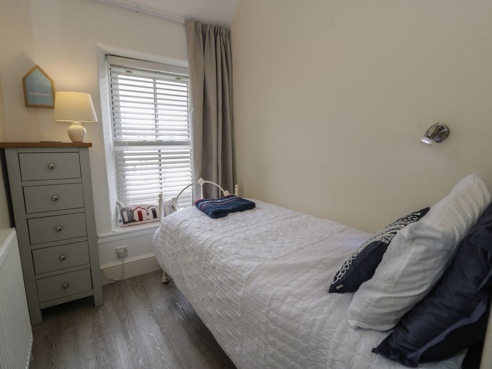 A bedroom with a bed and a dresser at The Hideaway in Penrhyn Bay