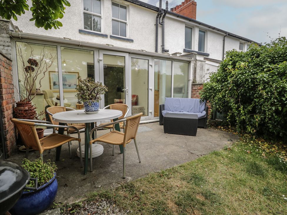 A garden area with a table and chairs at The Hideaway in Penrhyn Bay