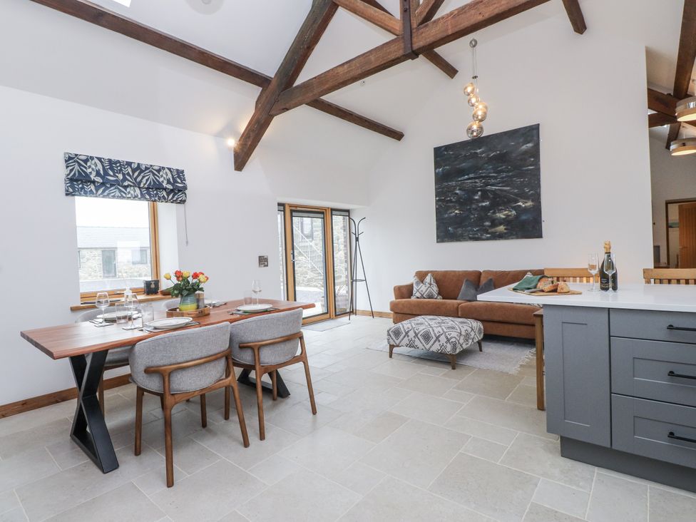 A living room with a dining table and sofa at 2 Trem Y Mor in Llanfwrog near Llanfachraeth