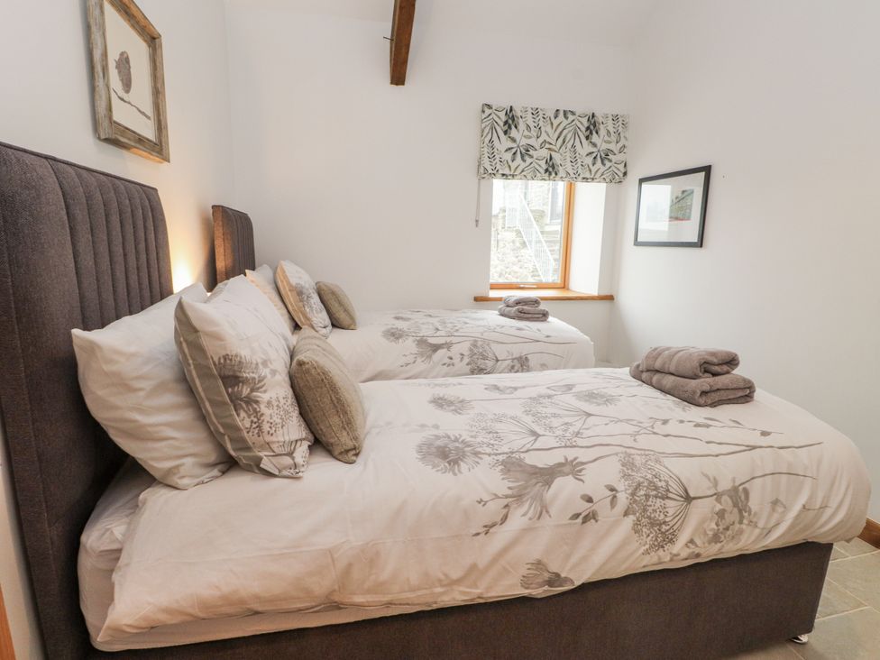 A bedroom with two single beds and a window at 2 Trem Y Mor Llanfwrog near Llanfachraeth