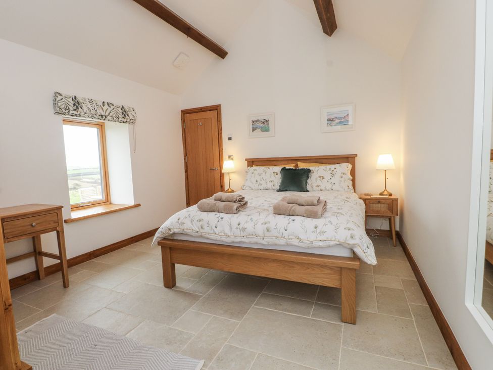 A bedroom with a bed and bedside table at 2 Trem Y Mor in Llanfwrog near Llanfachraeth