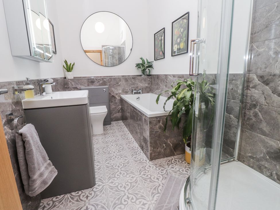 A bathroom with a sink, bathtub, shower, and toilet at 2 Trem Y Mor Llanfwrog near Llanfachraeth