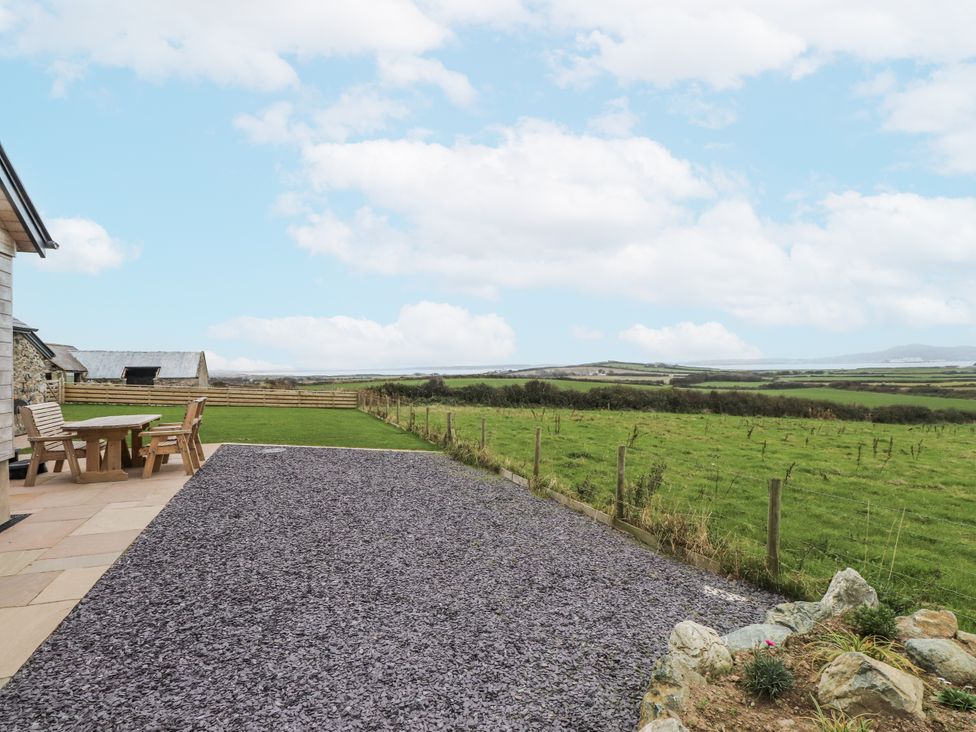 An outdoor area with a table and chairs at 2 Trem Y Mor Llanfwrog near Llanfachraeth