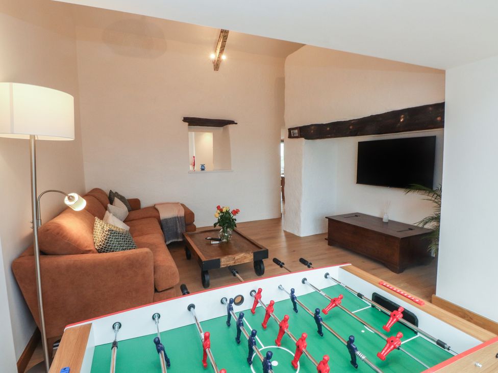 A living room with a foosball table and a sofa at Hen Penmynydd in Llanfwrog near Llanfachraeth