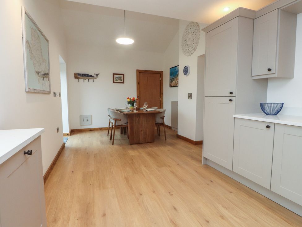 A dining room with a table and chairs at Hen Penmynydd in Llanfwrog near Llanfachraeth