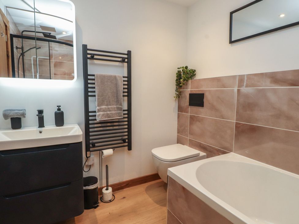 A bathroom with a sink and a bathtub at Hen Penmynydd Llanfwrog near Llanfachraeth