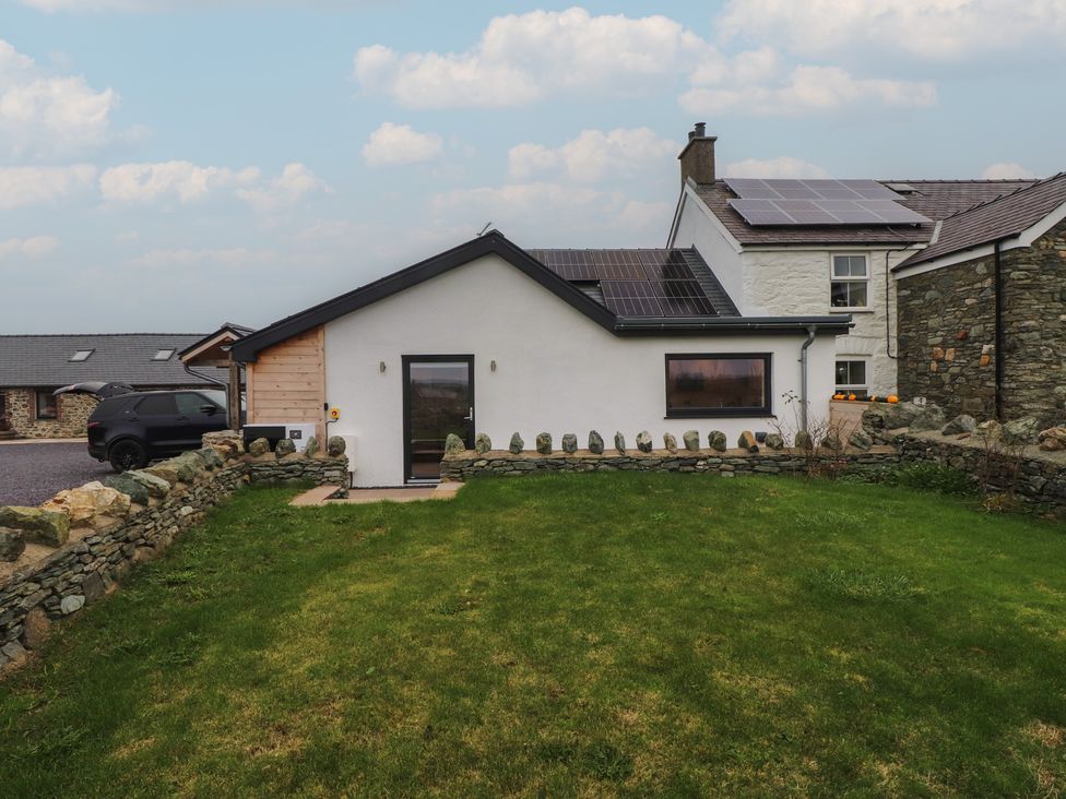 A house with a garden and stone wall at Hen Penmynydd in Llanfwrog near Llanfachraeth
