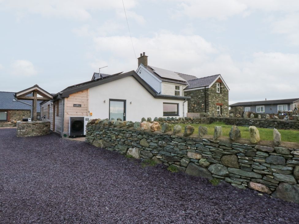 An exterior view of a house and stone wall at Hen Penmynydd Llanfwrog near Llanfachraeth