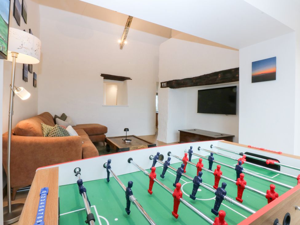A living room with a foosball table and a sofa at Hen Penmynydd in Llanfwrog near Llanfachraeth
