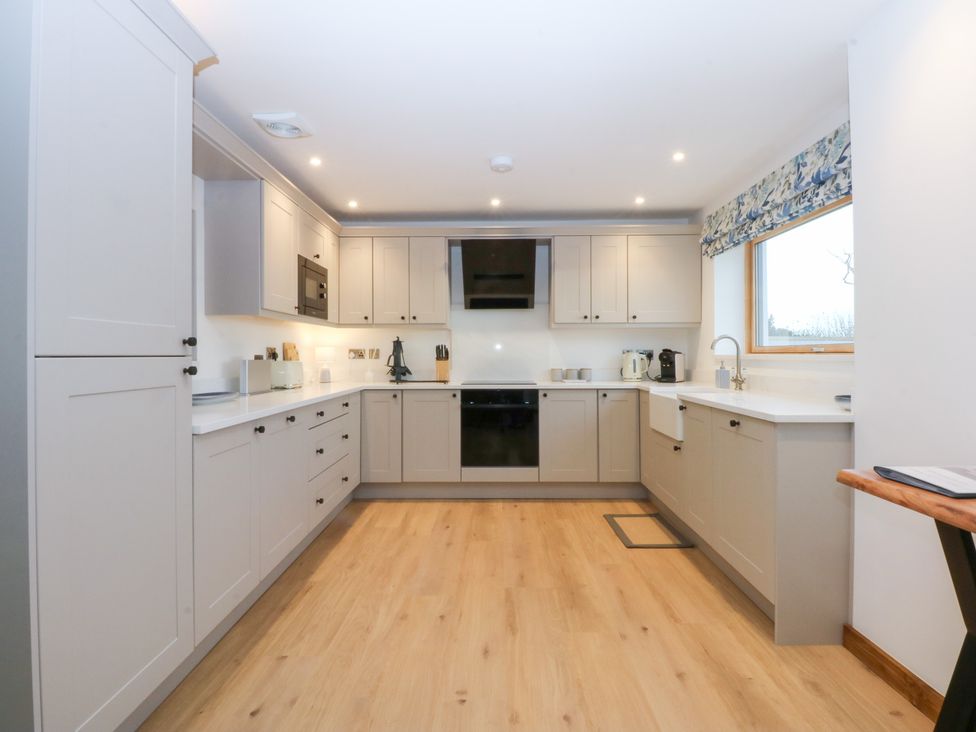 A kitchen with appliances and cabinets at Hen Penmynydd in Llanfwrog near Llanfachraeth