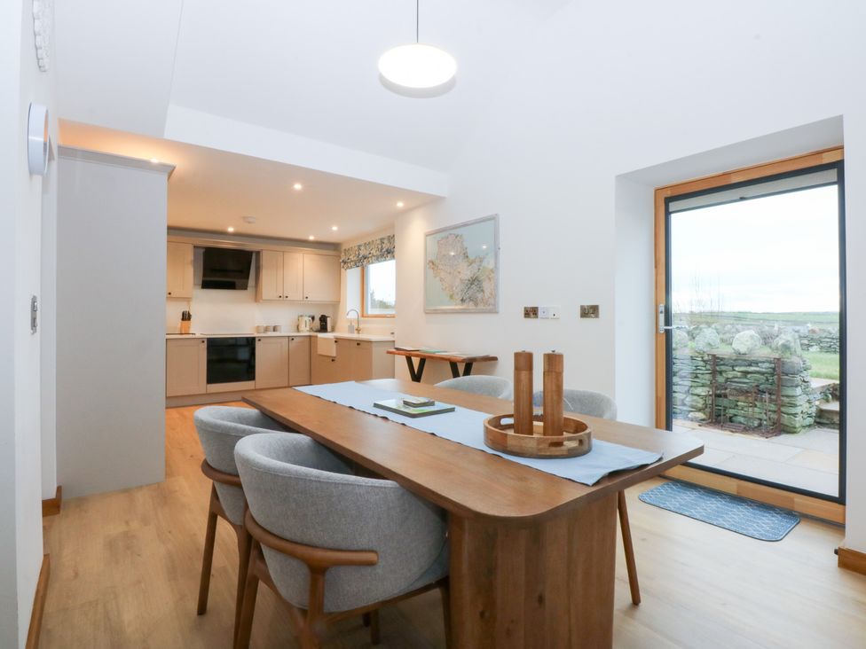 A dining room with a table and chairs at Hen Penmynydd Llanfwrog near Llanfachraeth