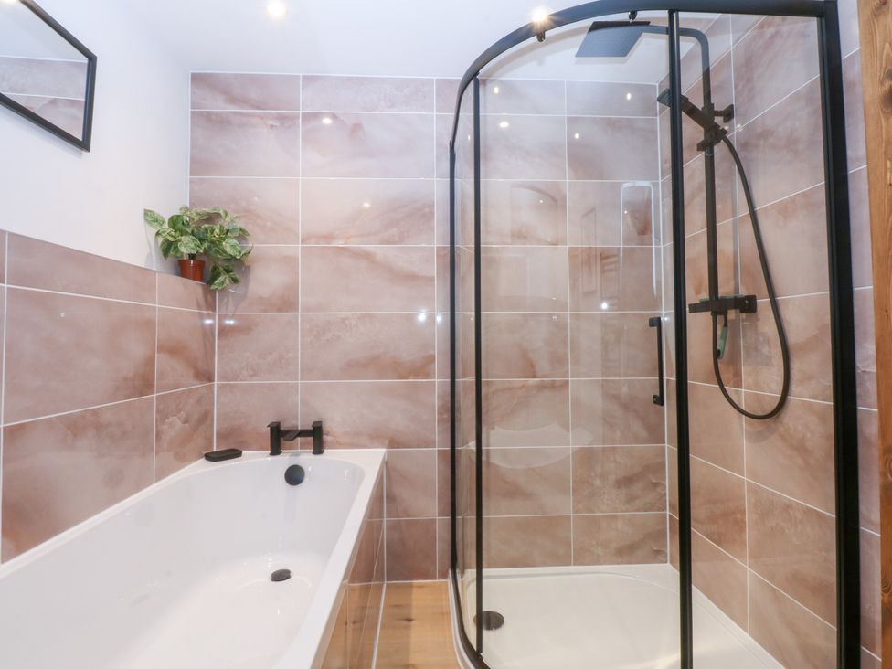 A bathroom with a bathtub and shower at Hen Penmynydd near Llanfwrog Llanfachraeth