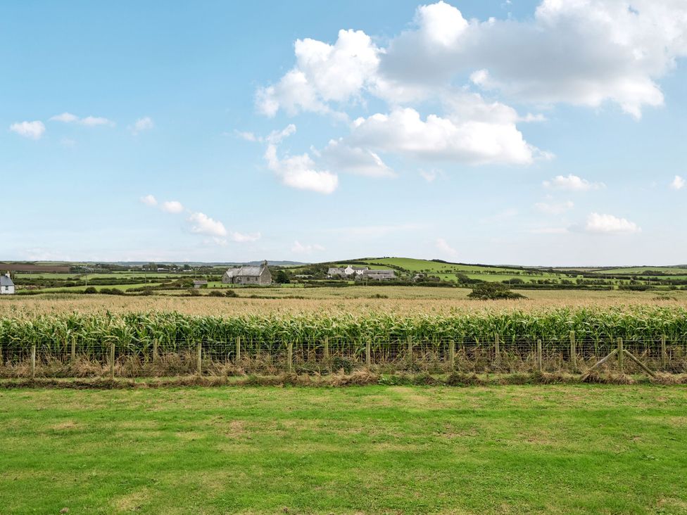 A landscape view with cornfield and houses at Hen Penmynydd in Llanfwrog near Llanfachraeth