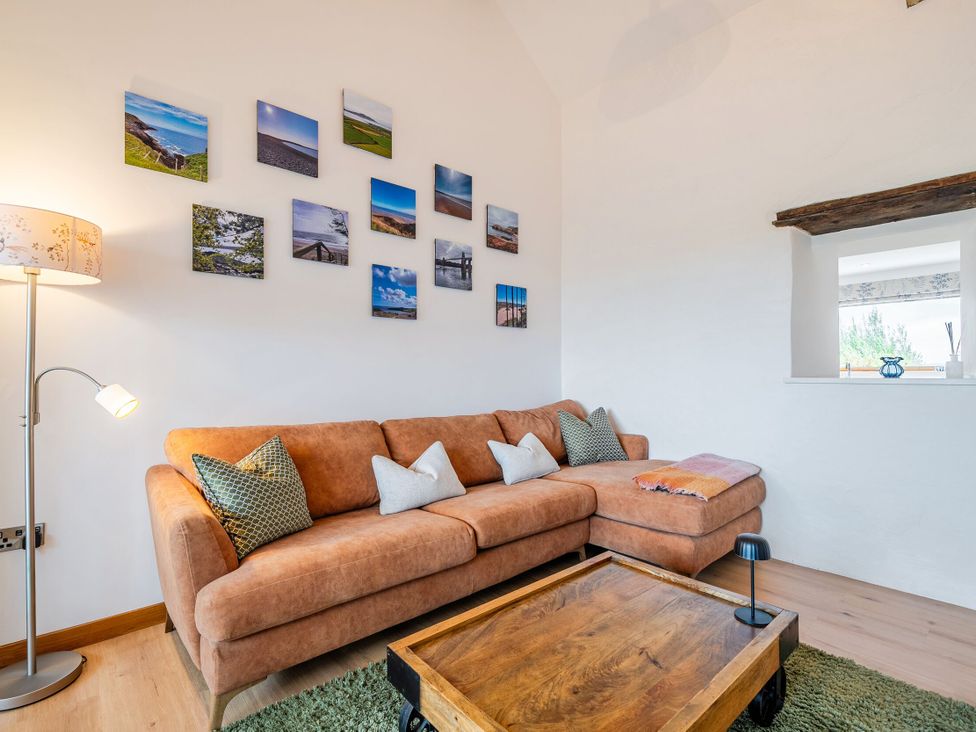 A living room with a sofa and a coffee table at Hen Penmynydd in Llanfwrog near Llanfachraeth