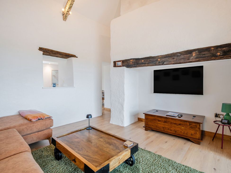 A living room with a sofa and television at Hen Penmynydd in Llanfwrog near Llanfachraeth