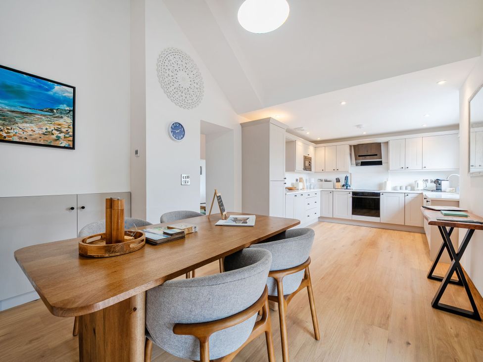 A kitchen with a dining table and chairs at Hen Penmynydd Llanfwrog near Llanfachraeth